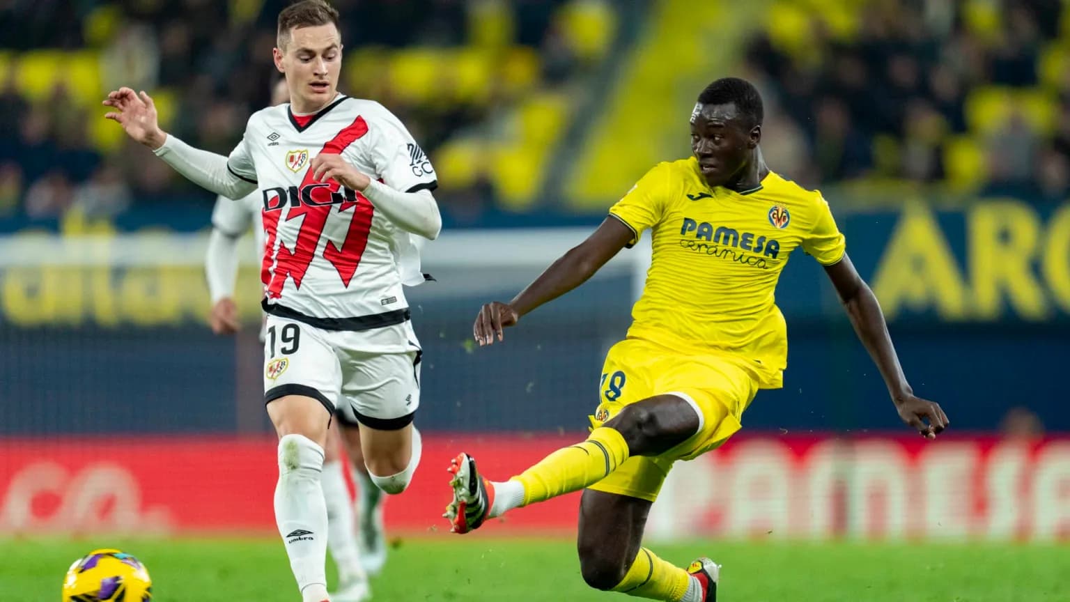 Rayo Vallecano player competing against Villarreal player Rayo Vallecano player competing against Villarreal player