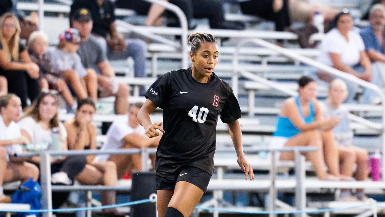 Soccer player in black uniform running on field Soccer player in black uniform running on field