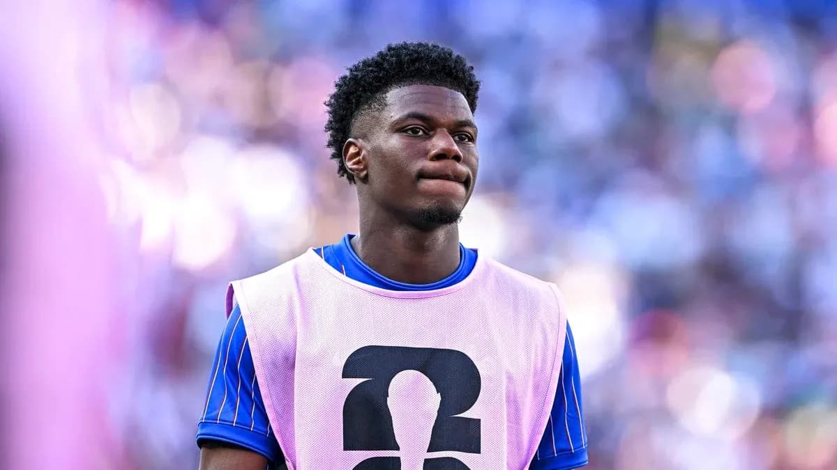 Player in training bib on sidelines during match Player in training bib on sidelines during match