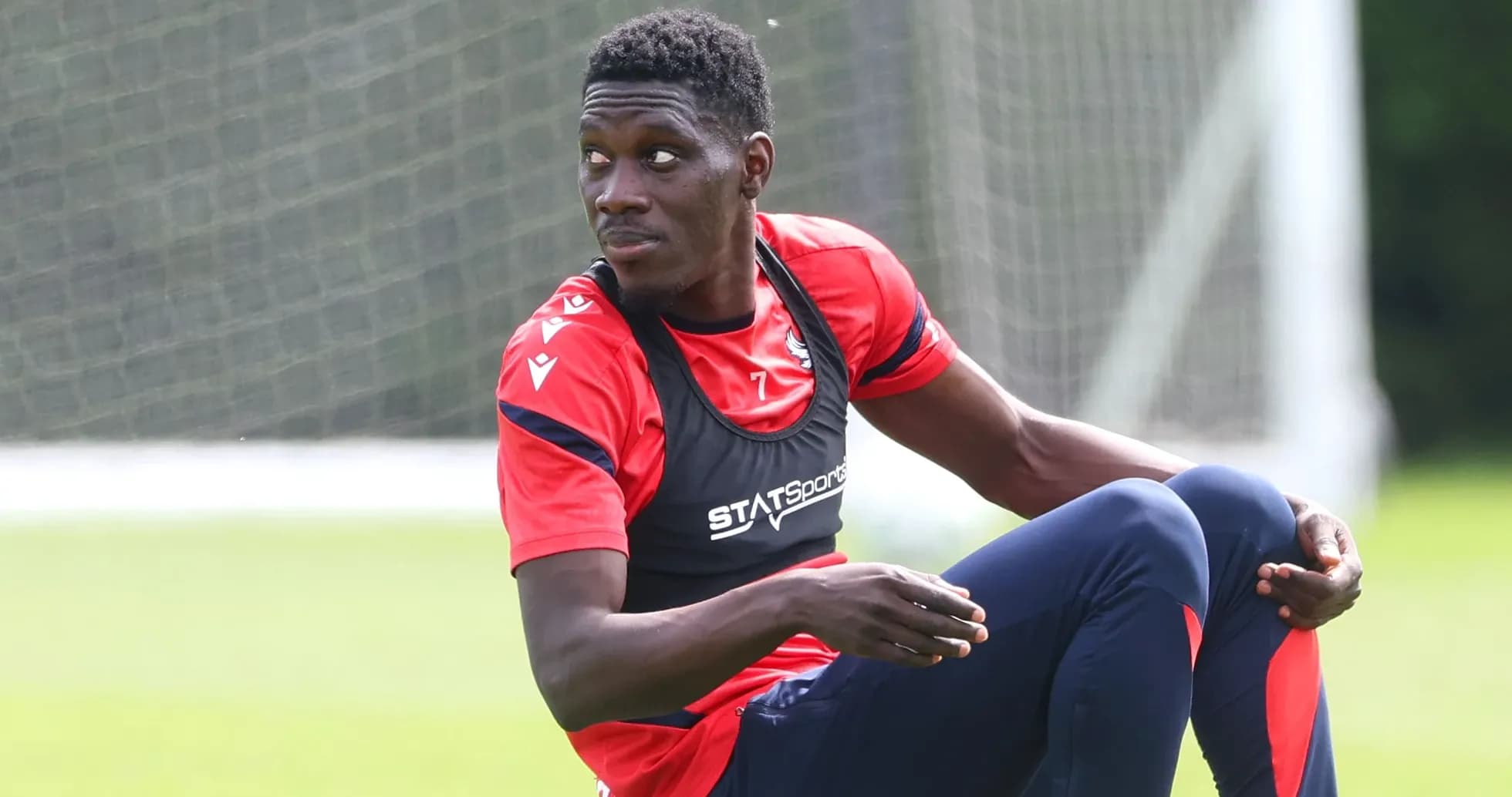 Player sitting on training pitch during practice session Player sitting on training pitch during practice session