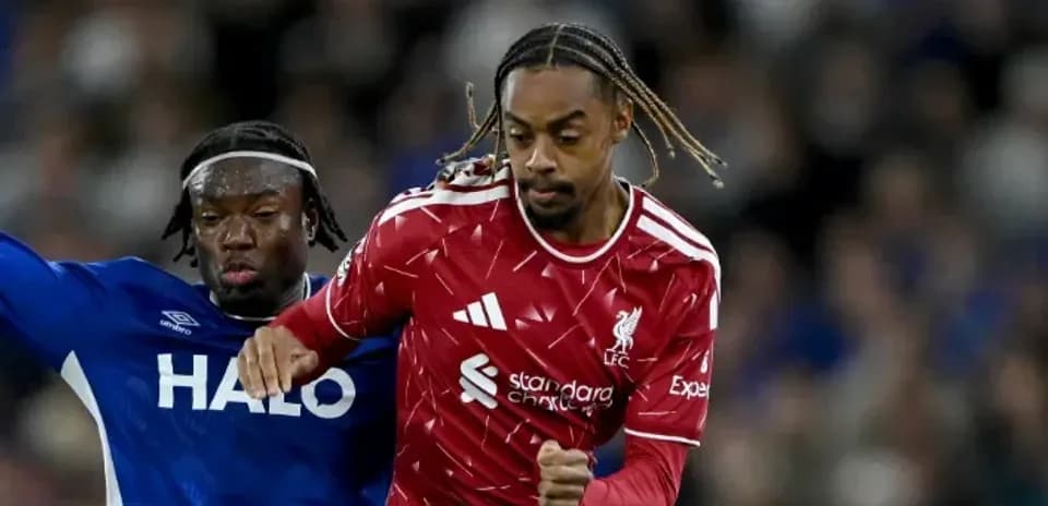 Liverpool player running past opponent during match Liverpool player running past opponent during match