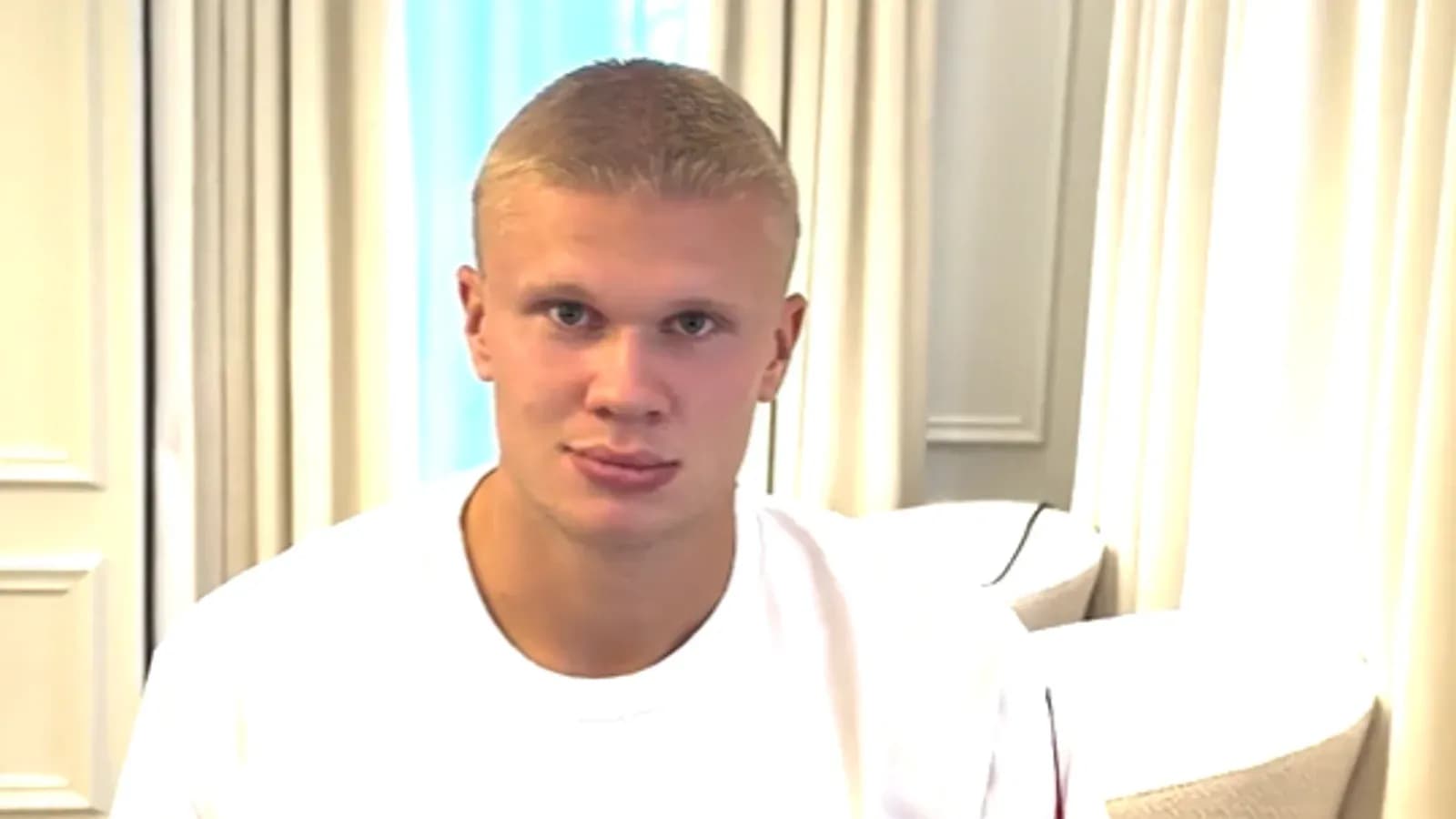 Young man sitting indoors wearing a white t-shirt Young man sitting indoors wearing a white t-shirt