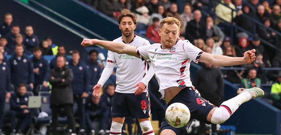Player kicking ball during football match action Player kicking ball during football match action