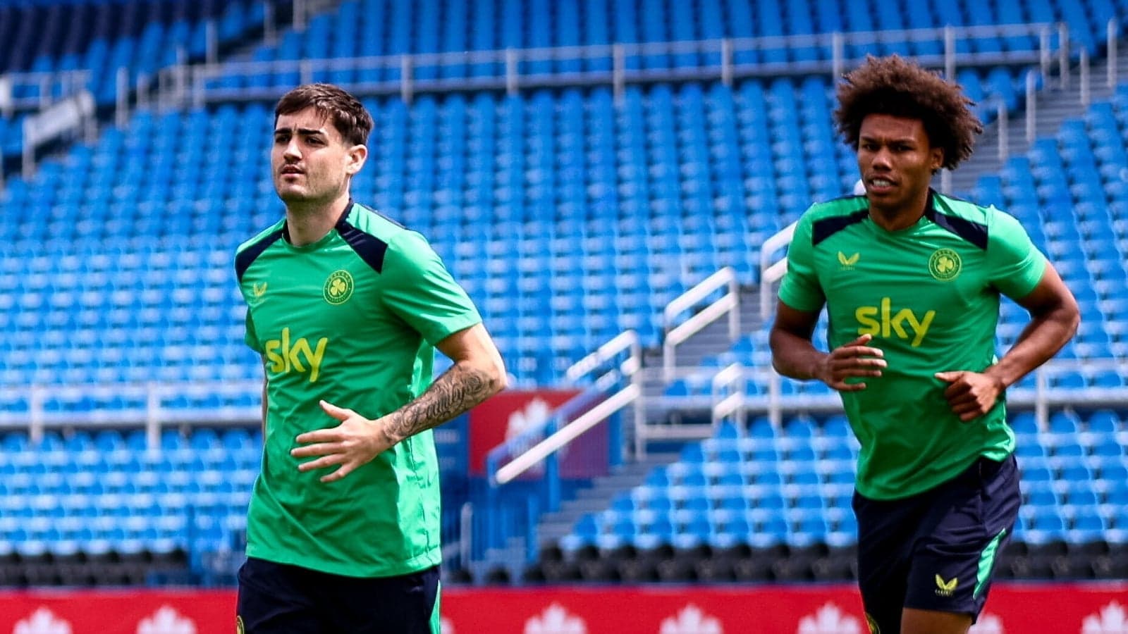 Two players jogging during training session on pitch Two players jogging during training session on pitch
