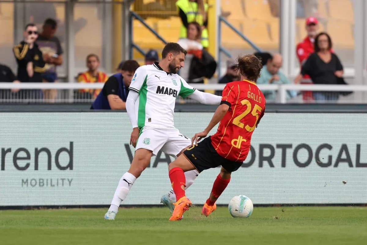 Sassuolo player tackling Lecce opponent on field Sassuolo player tackling Lecce opponent on field