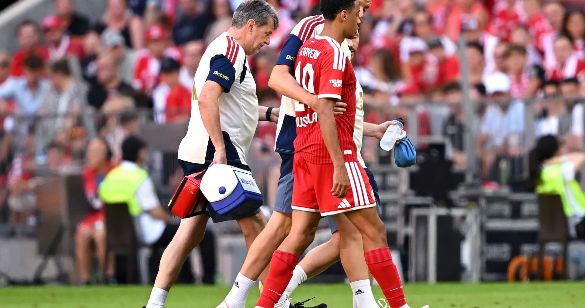 Player being assisted off the field by medical staff Player being assisted off the field by medical staff