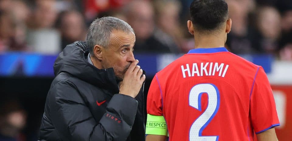 Coach giving instructions to player Hakimi on field Coach giving instructions to player Hakimi on field