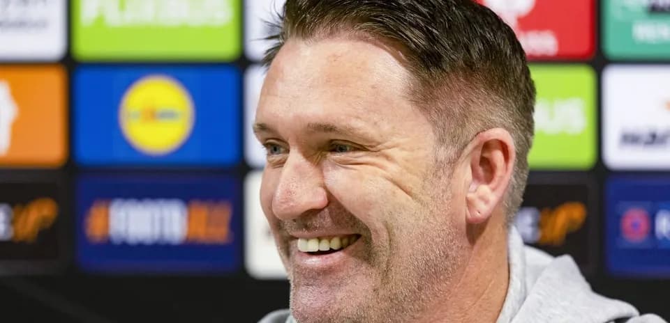 Man smiling during a press conference backdrop Man smiling during a press conference backdrop
