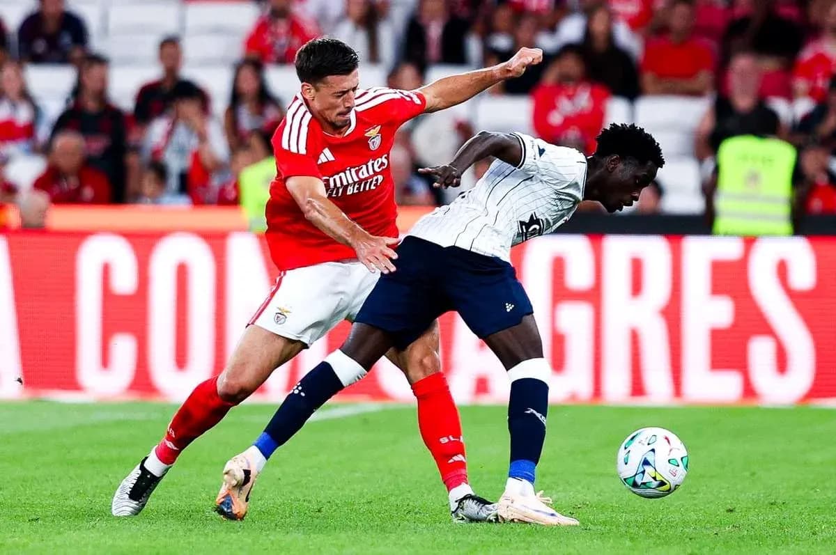 Benfica player tackling Aarhus opponent during match Benfica player tackling Aarhus opponent during match