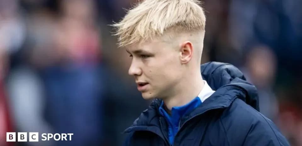 Player in a blue jacket walking on the field Player in a blue jacket walking on the field