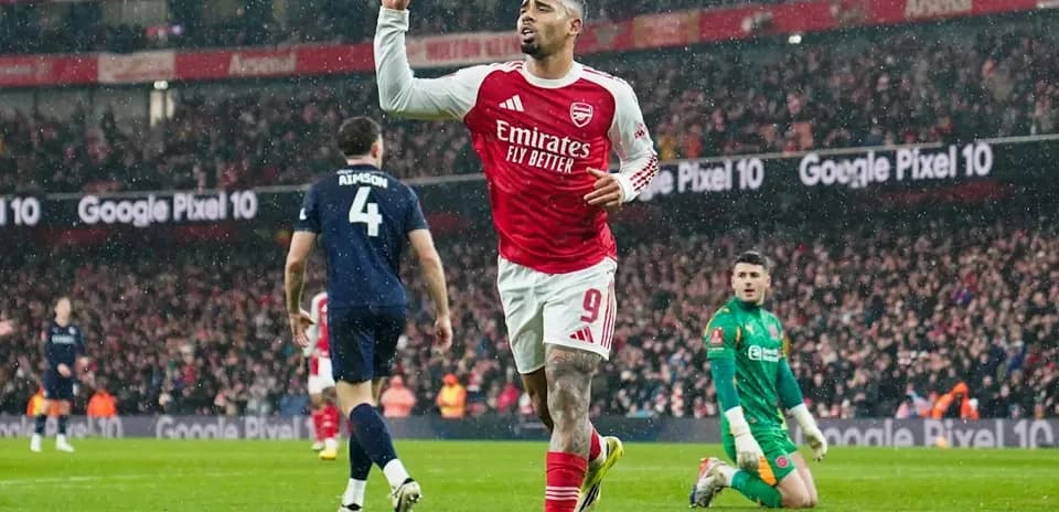 Arsenal player celebrating goal in rainy match Arsenal player celebrating goal in rainy match