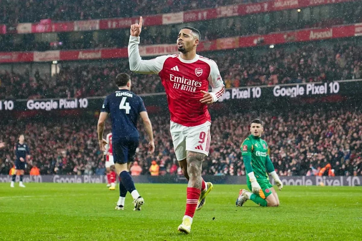 Arsenal player celebrating goal in rainy match Arsenal player celebrating goal in rainy match