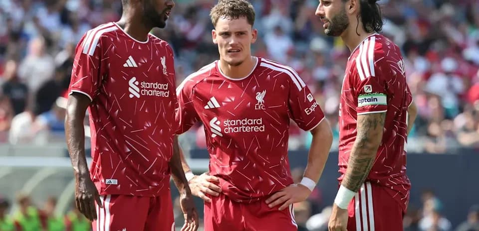 Three Liverpool players discussing on the field Three Liverpool players discussing on the field
