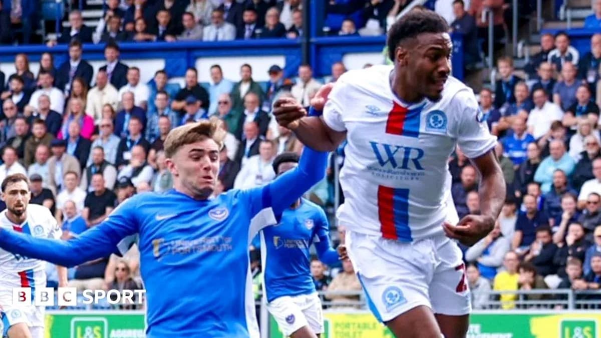 Player in blue jersey tackling opponent in white jersey Player in blue jersey tackling opponent in white jersey