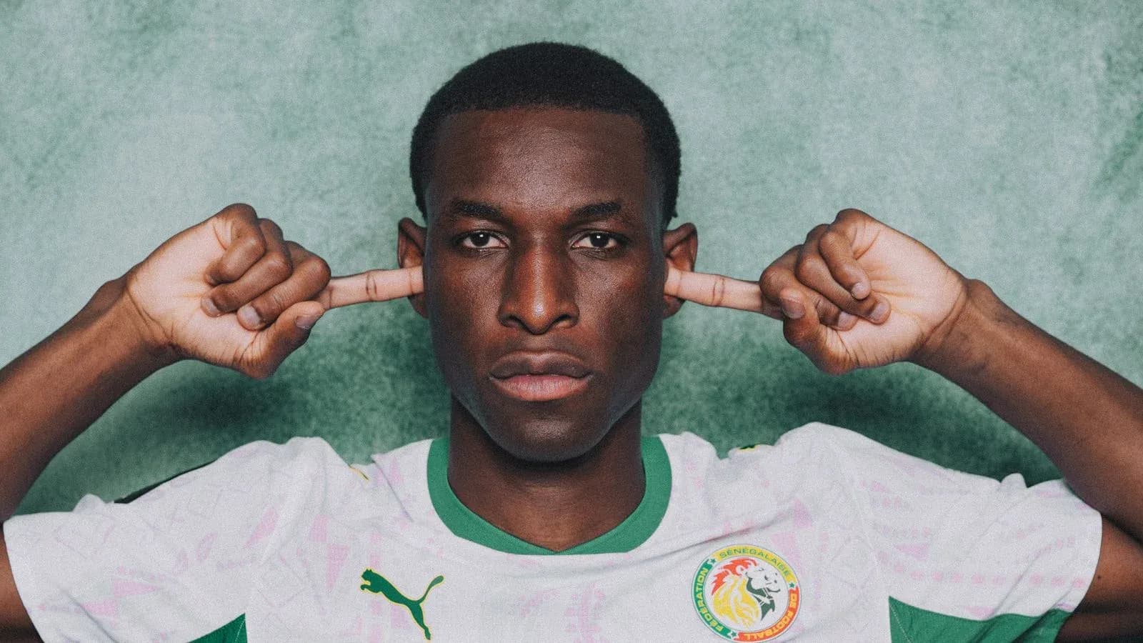Football player in Senegal jersey covering ears Football player in Senegal jersey covering ears