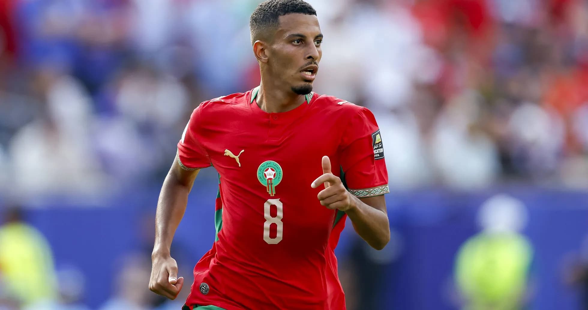 Player in red Morocco jersey running on field Player in red Morocco jersey running on field