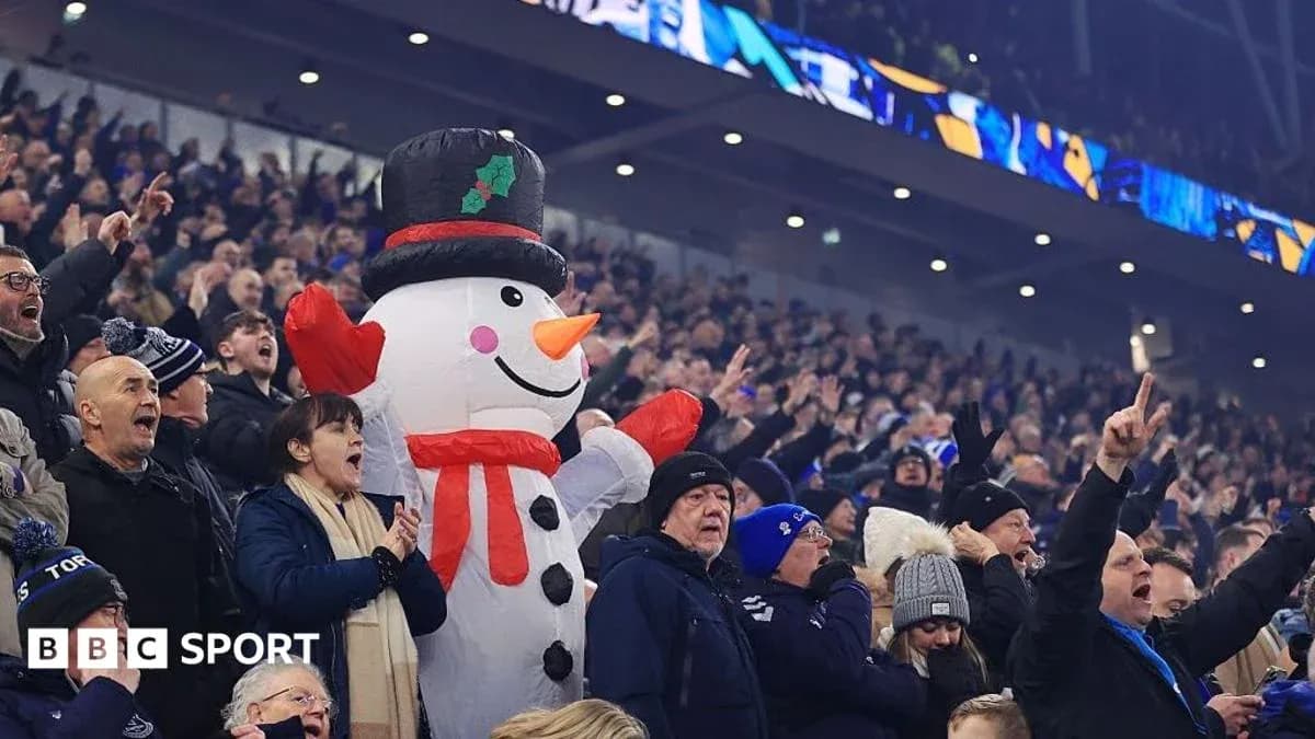 Fans cheering with inflatable snowman at stadium Fans cheering with inflatable snowman at stadium