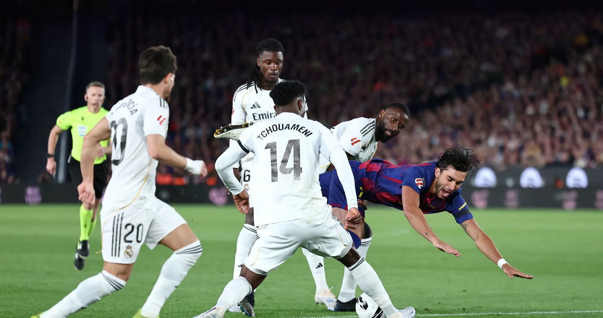 Barcelona player falling amid Real Madrid defenders Barcelona player falling amid Real Madrid defenders