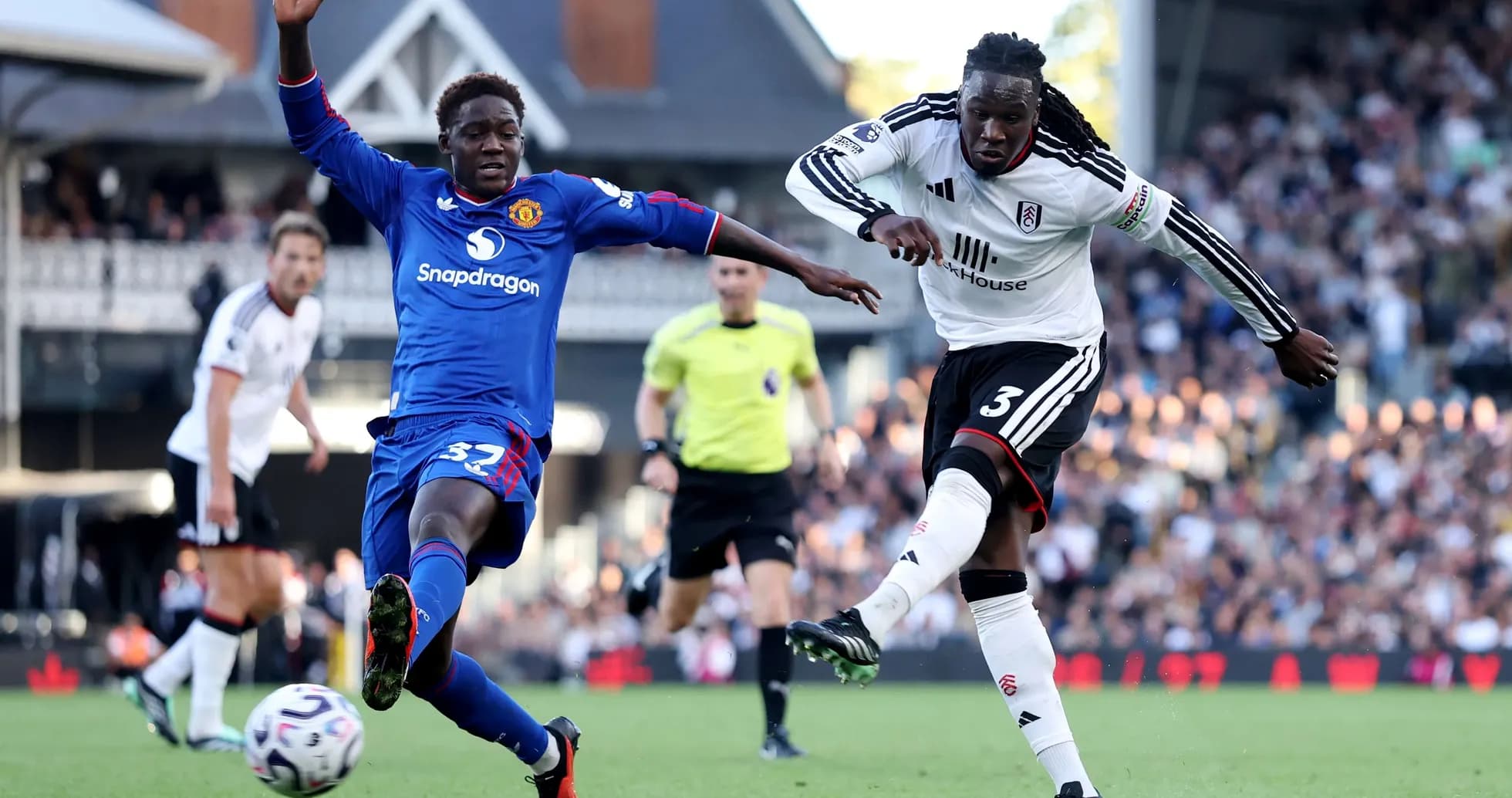 Fulham player tackling Manchester United opponent Fulham player tackling Manchester United opponent