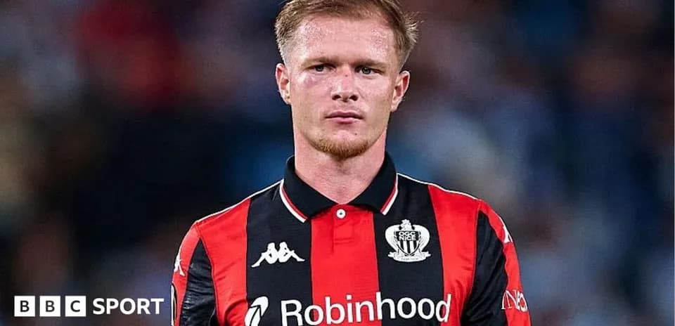 Player in black and red kit during match Player in black and red kit during match