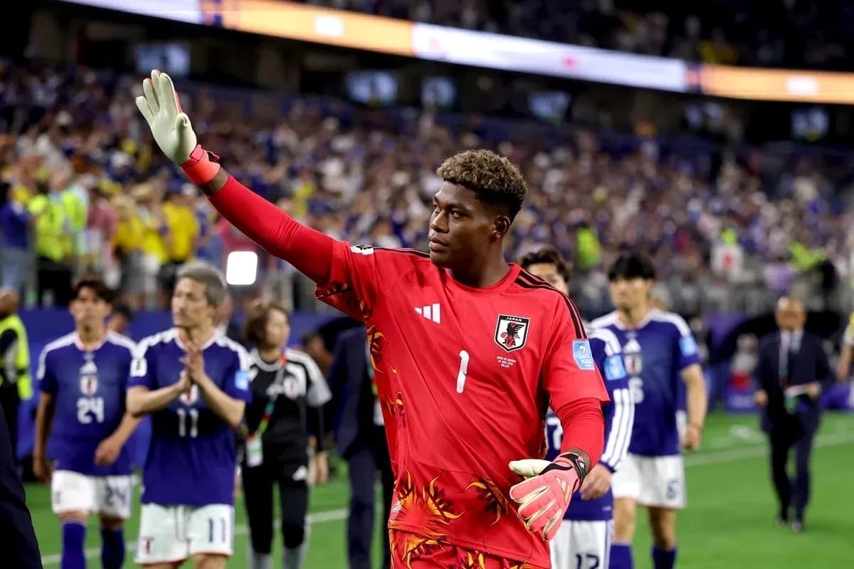 Goalkeeper waving after match with teammates behind Goalkeeper waving after match with teammates behind