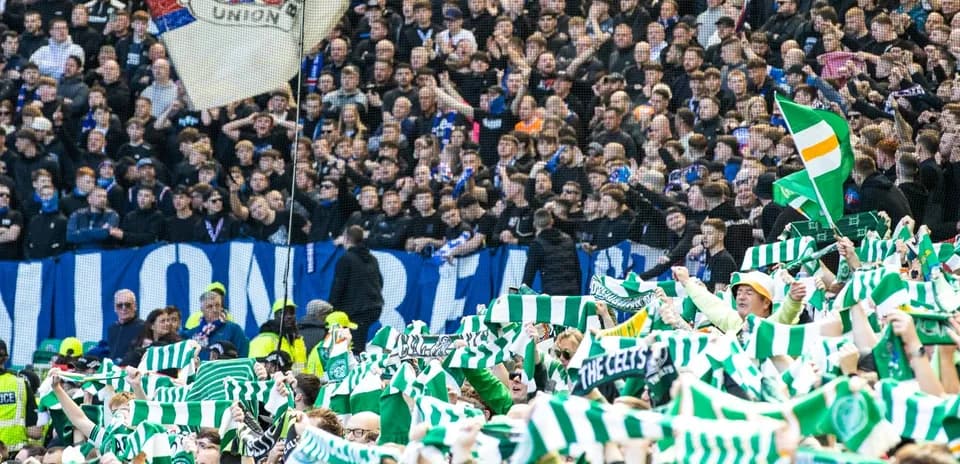 Celtic fans waving scarves in stadium stands Celtic fans waving scarves in stadium stands