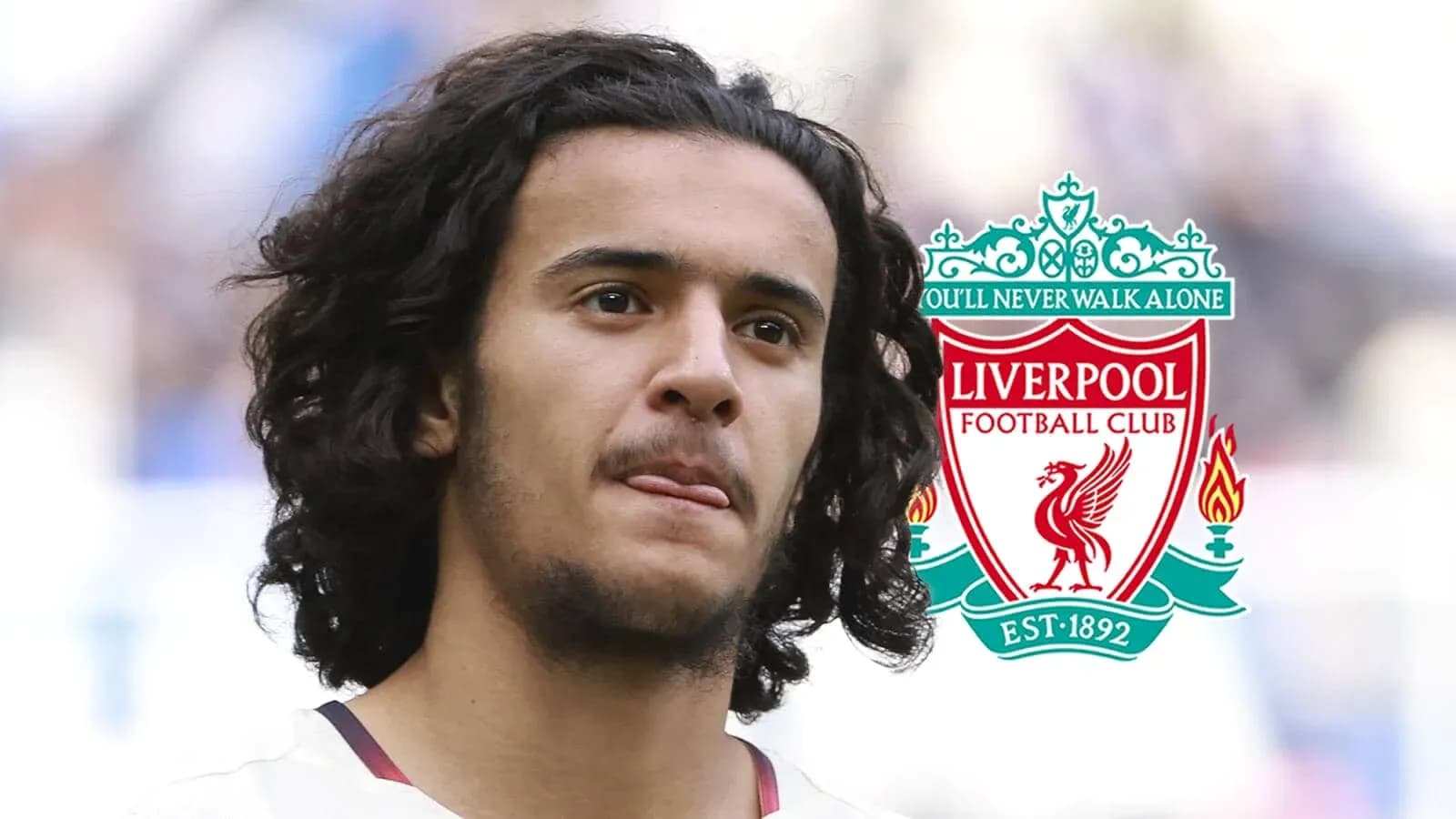 Player with long hair in front of Liverpool FC logo Player with long hair in front of Liverpool FC logo