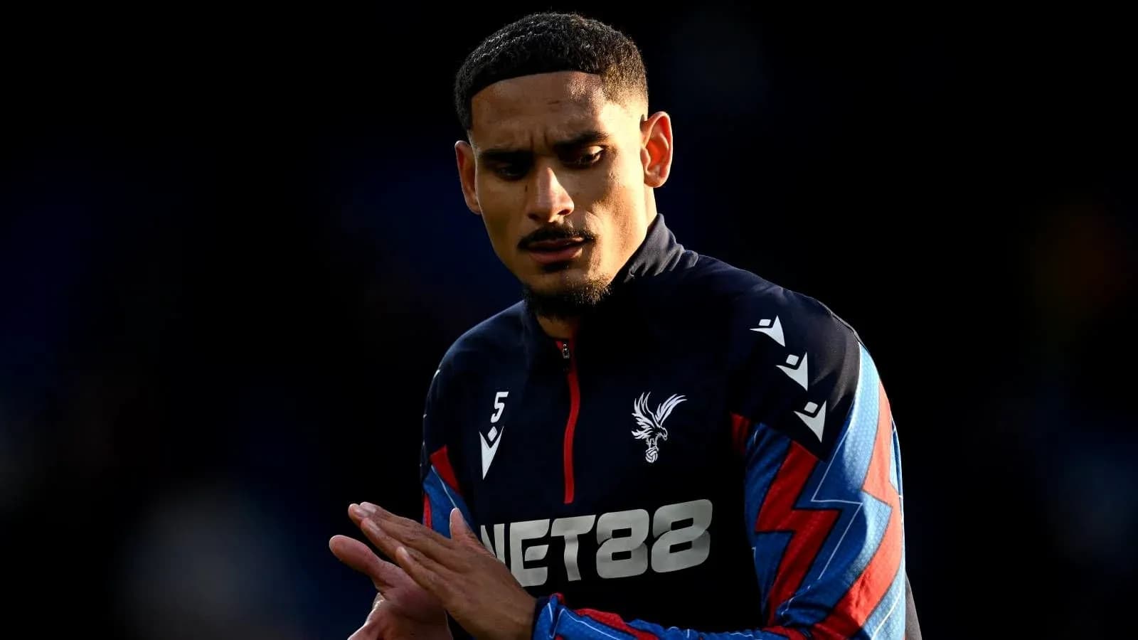 Player in Crystal Palace kit warming up on field Player in Crystal Palace kit warming up on field