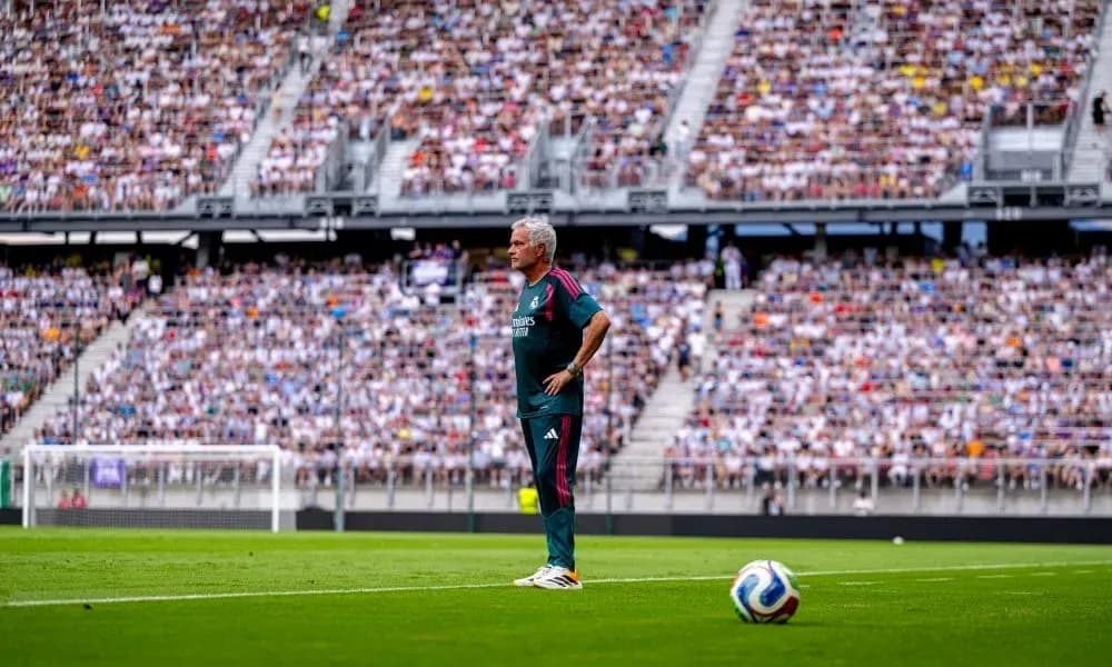 Coach observing the game with a packed stadium Coach observing the game with a packed stadium