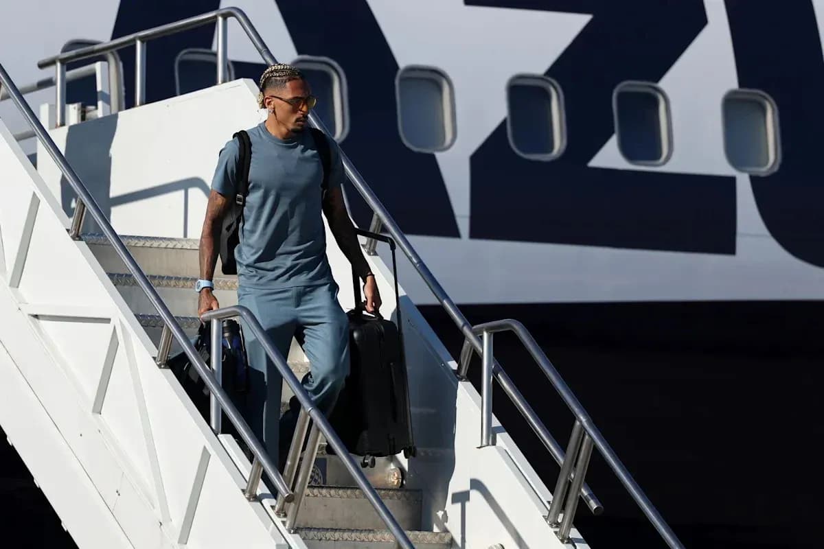 Player exiting airplane with suitcase at airport Player exiting airplane with suitcase at airport