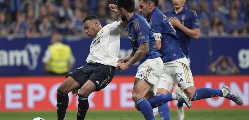 Real Madrid player challenged by Oviedo defenders Real Madrid player challenged by Oviedo defenders