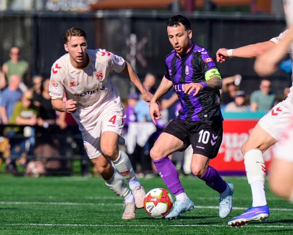 Cavalry FC player chasing the ball against Pacific FC Cavalry FC player chasing the ball against Pacific FC