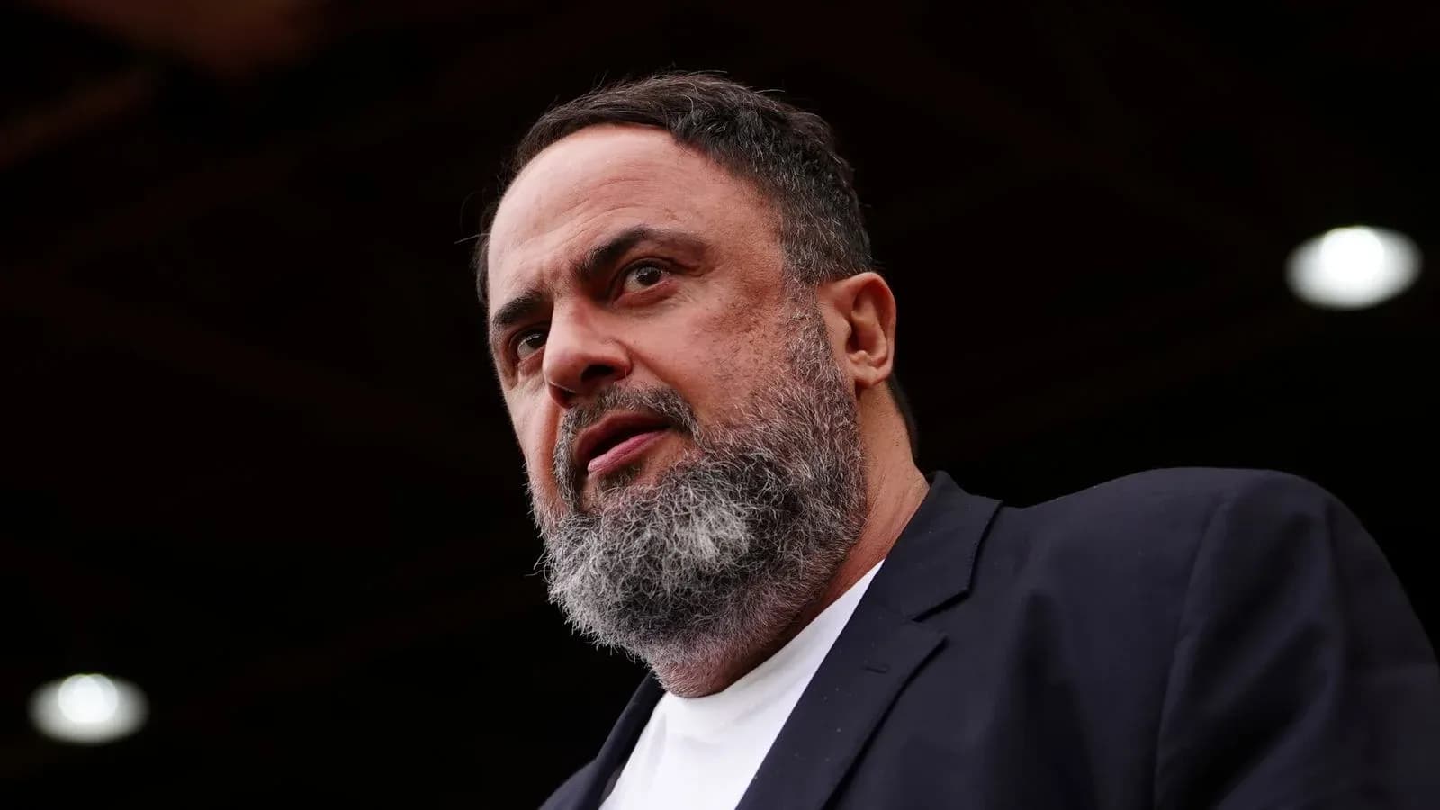 Man speaking at an outdoor event with a serious expression Man speaking at an outdoor event with a serious expression
