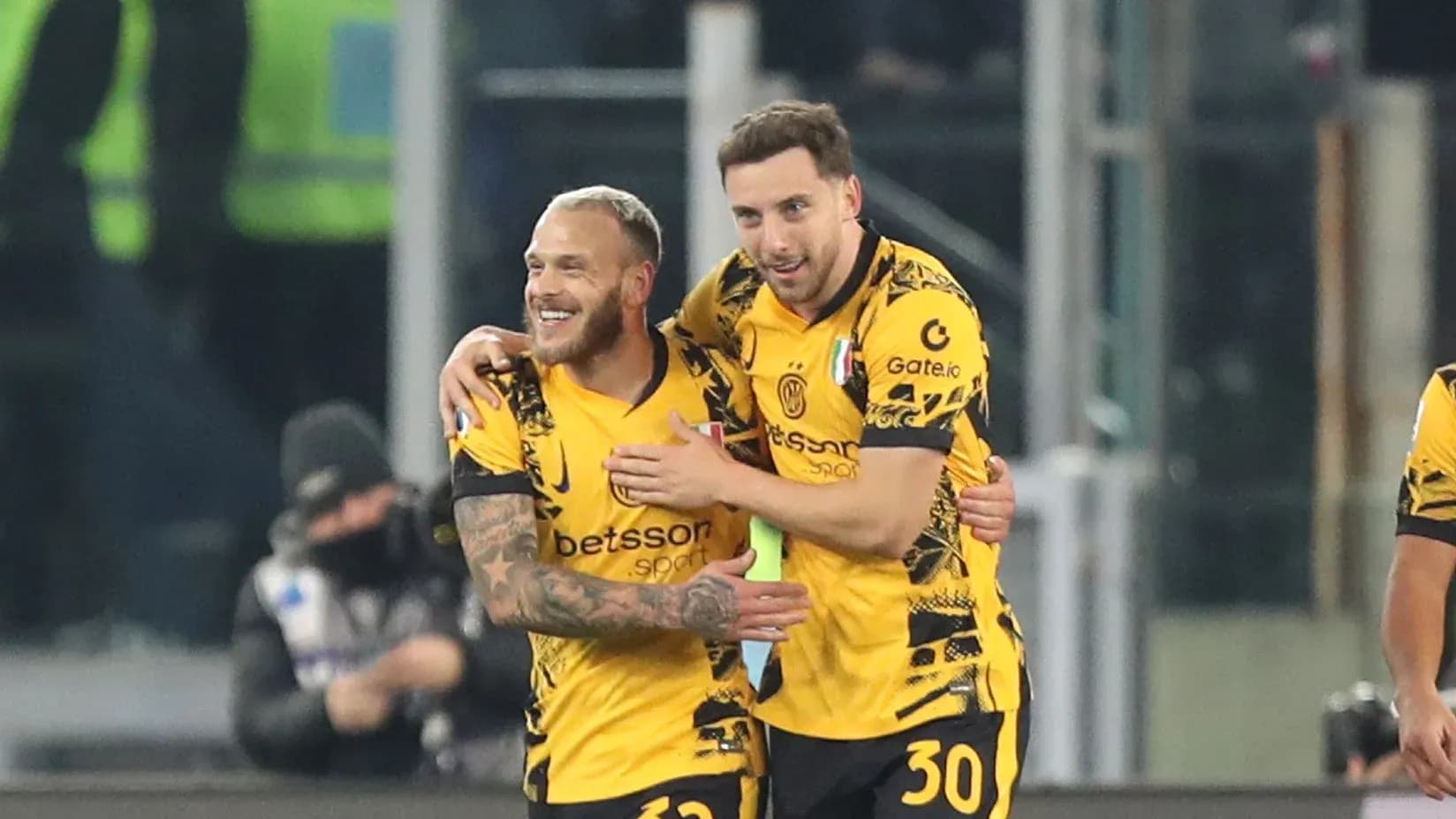 Two players celebrating a goal in yellow jerseys Two players celebrating a goal in yellow jerseys