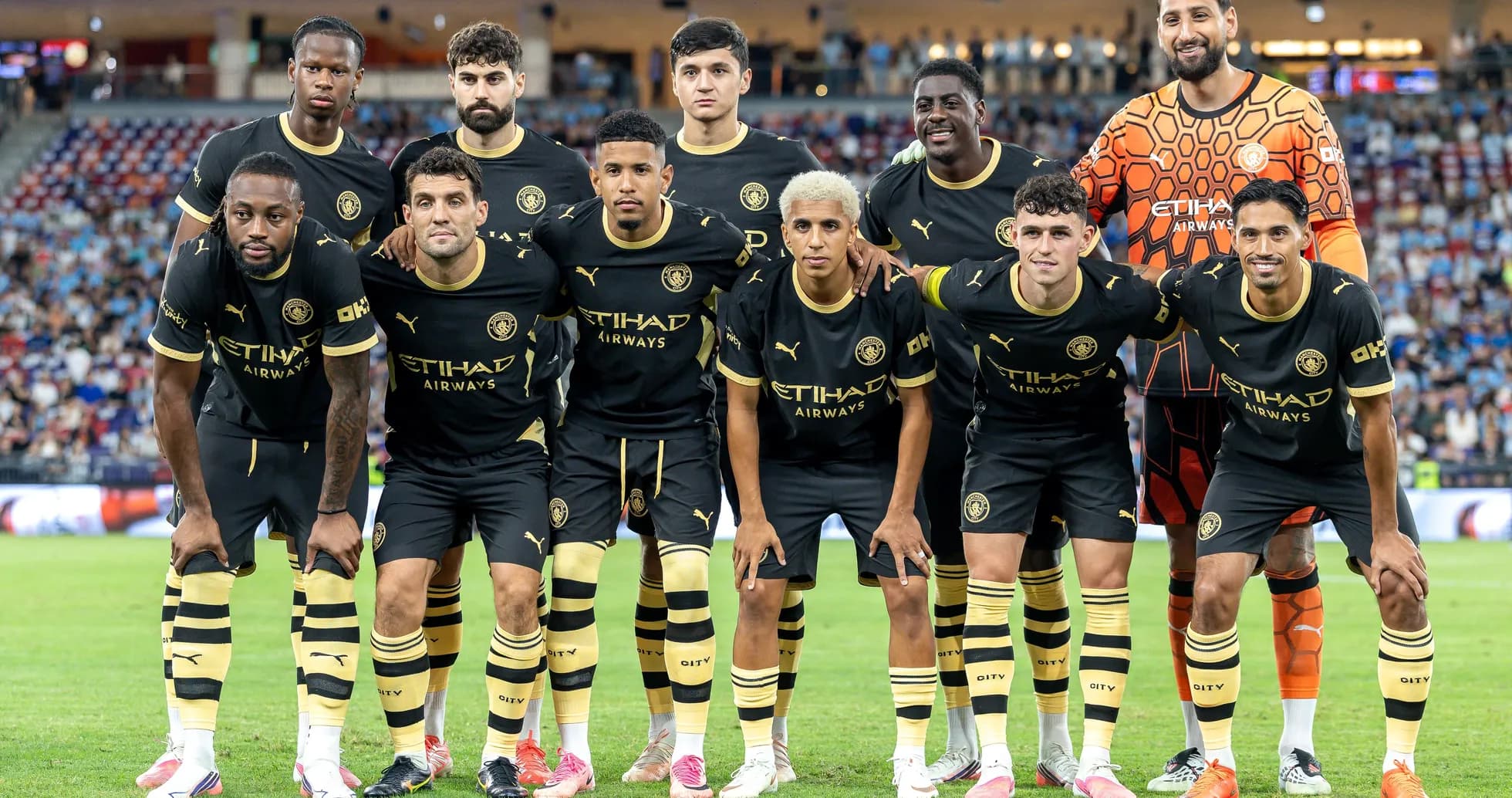 Soccer team posing for group photo in black kits Soccer team posing for group photo in black kits