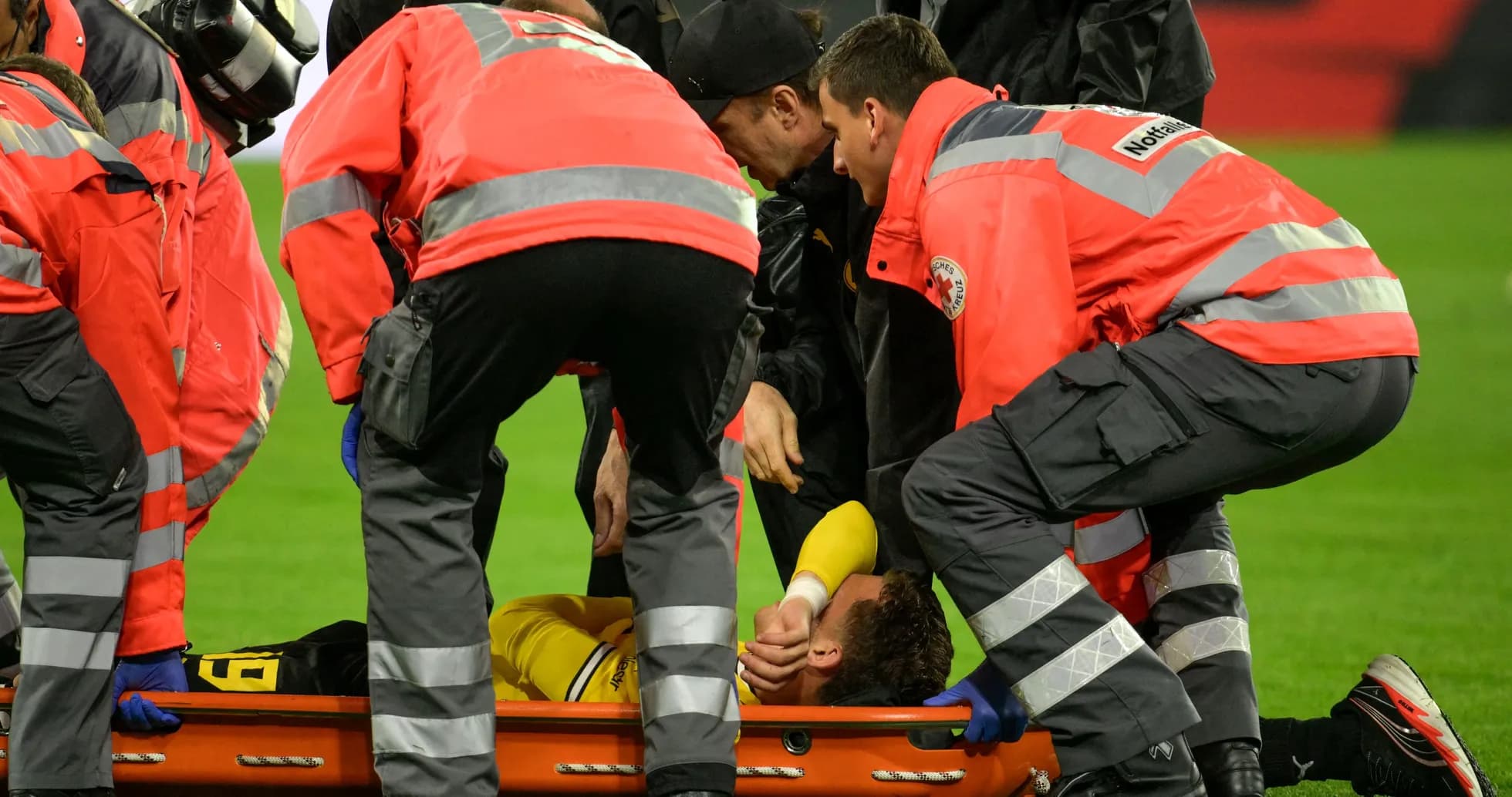 Medical team assisting injured player on stretcher Medical team assisting injured player on stretcher