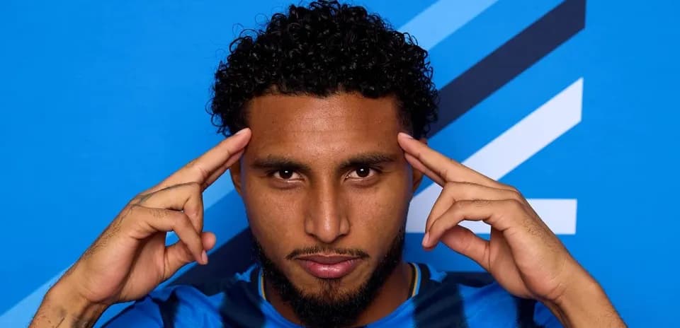 Player posing with fingers on temples against blue background Player posing with fingers on temples against blue background