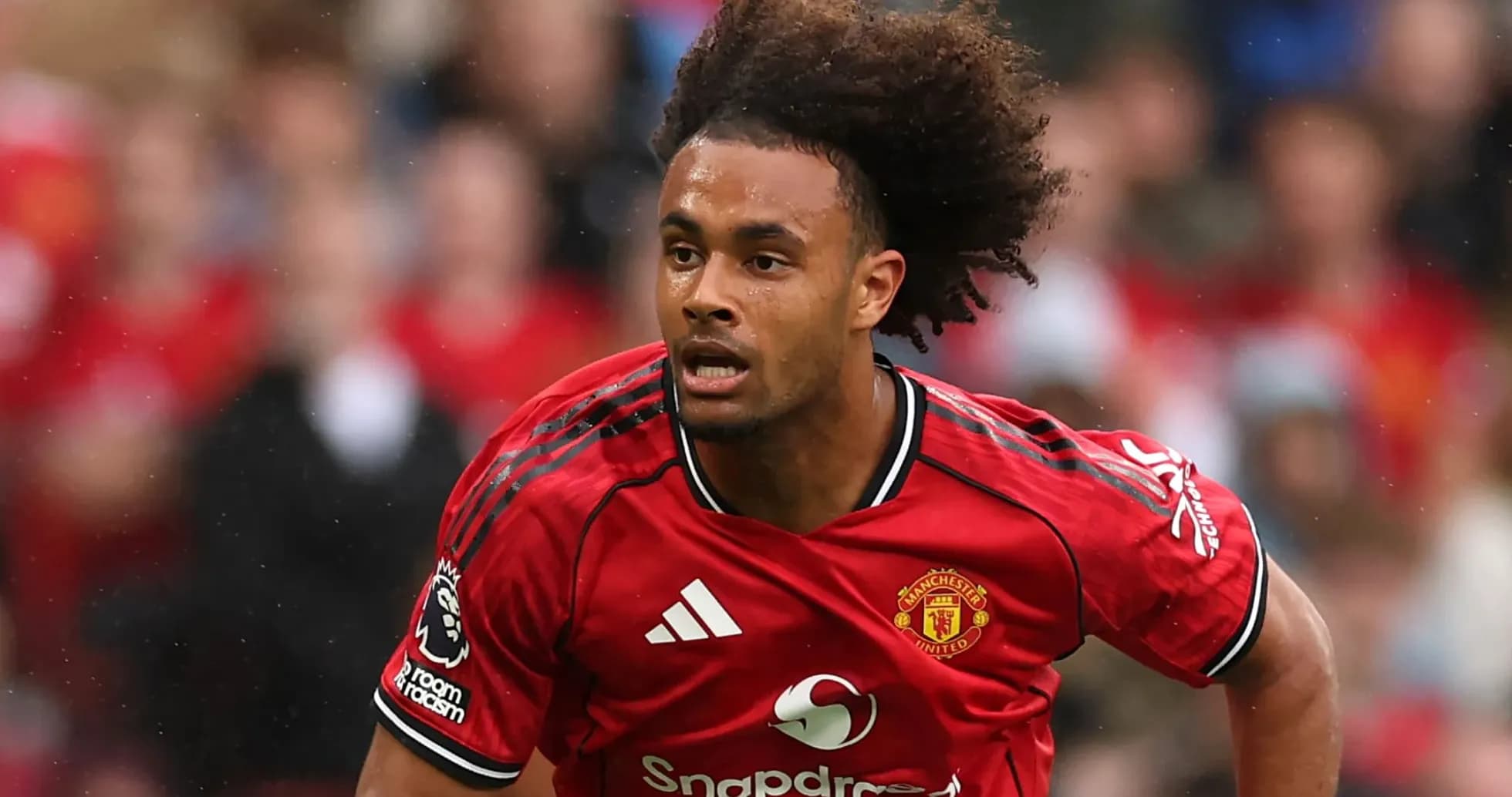 Player in red Manchester United kit running on field Player in red Manchester United kit running on field