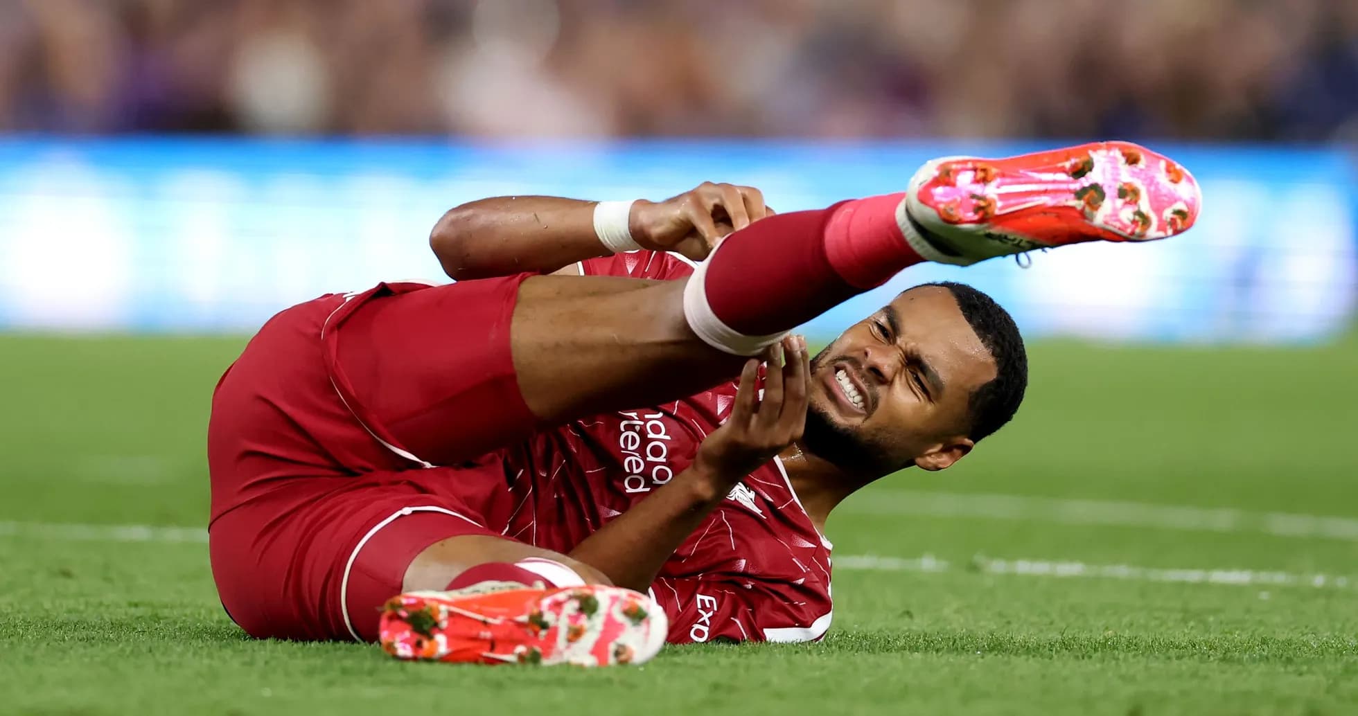 Player on ground holding injured leg during match Player on ground holding injured leg during match