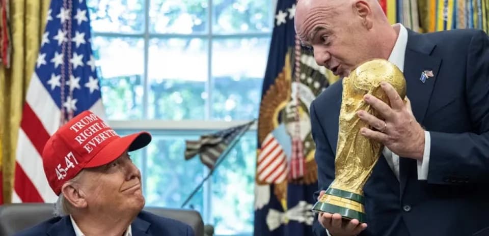 Man holding World Cup trophy with another man Man holding World Cup trophy with another man