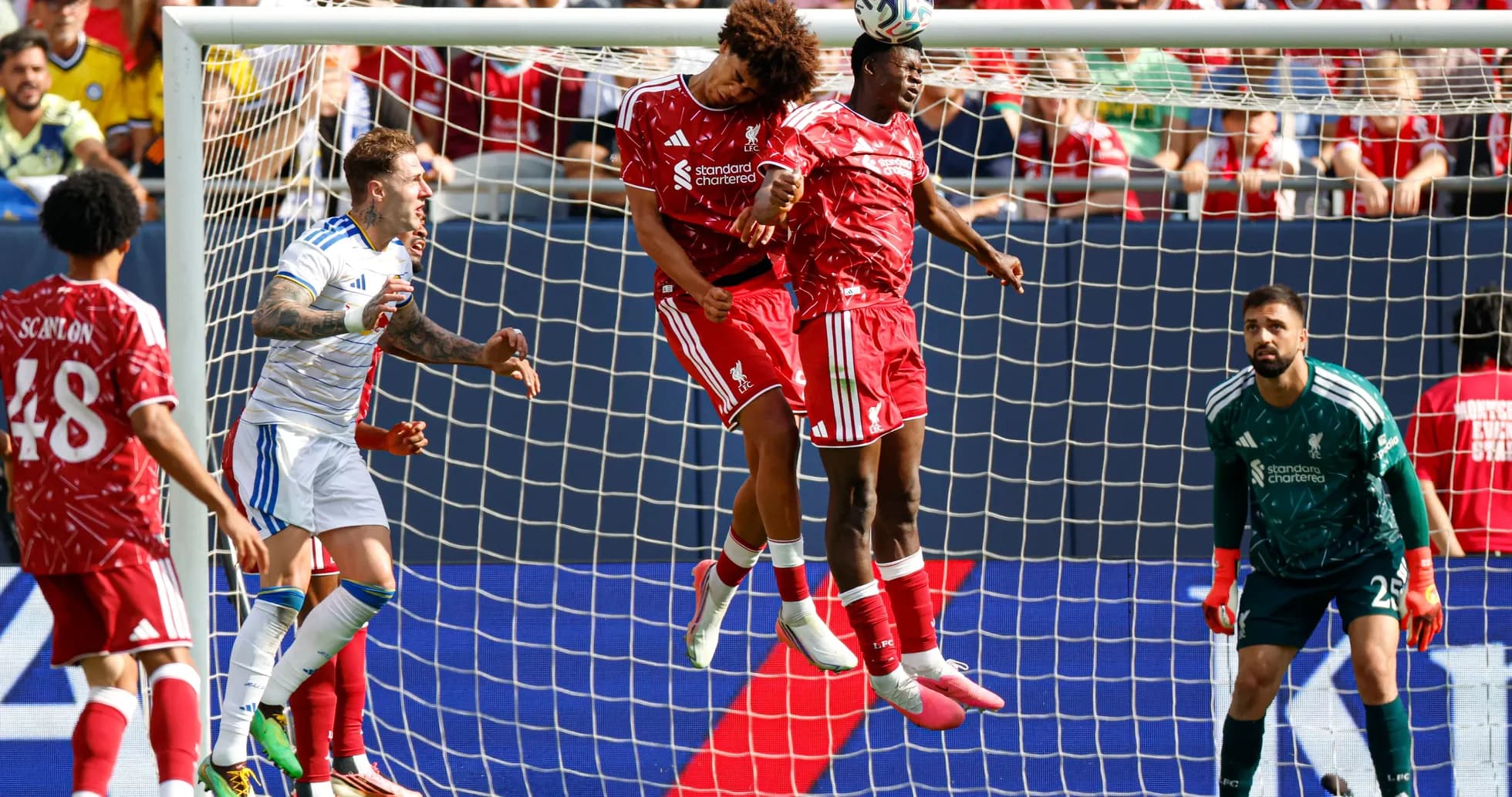 Two players heading the ball in front of goal Two players heading the ball in front of goal