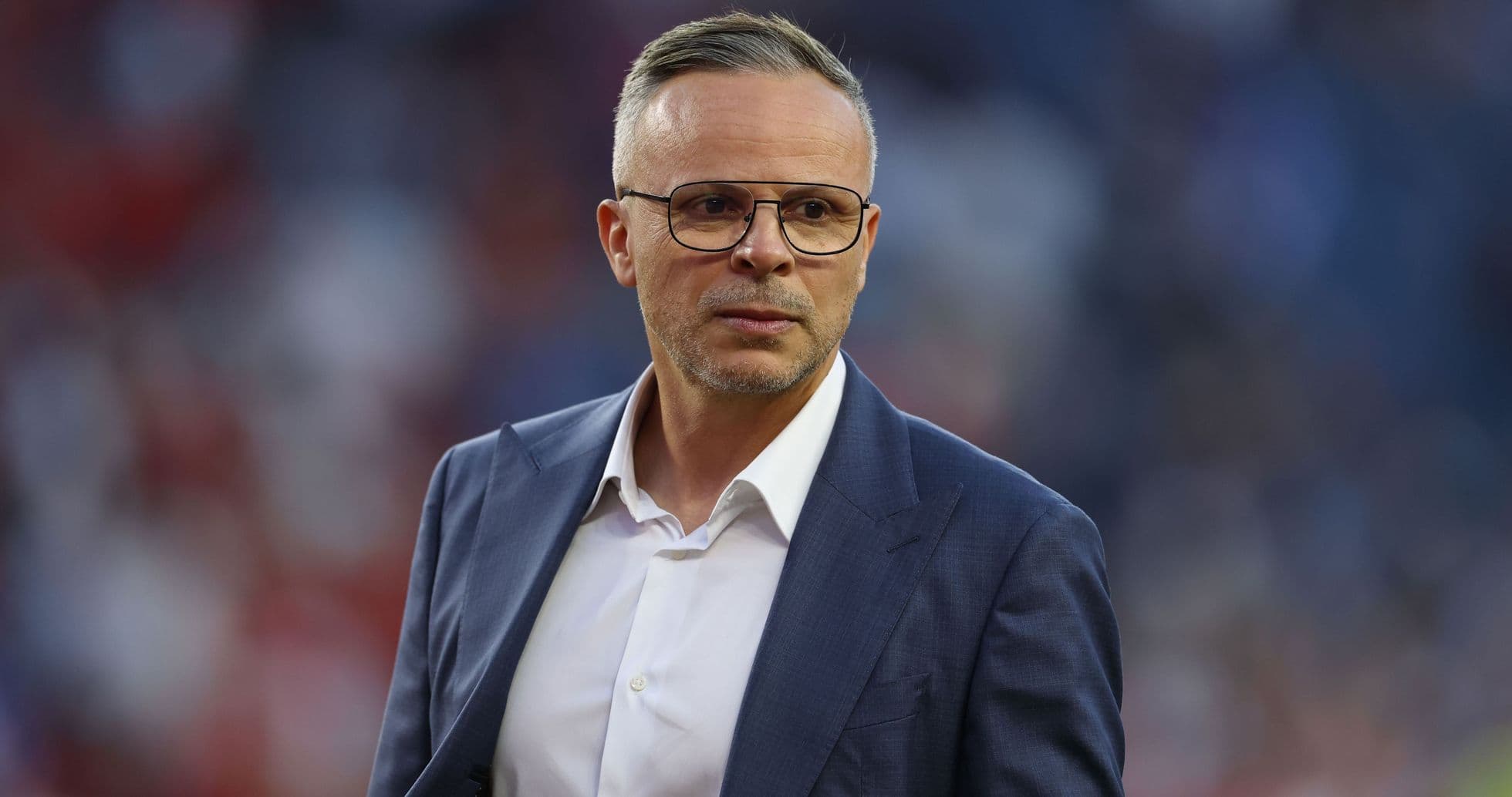 Man in suit with glasses on stadium field Man in suit with glasses on stadium field