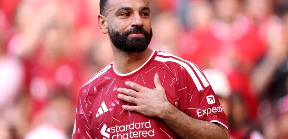 Player in red jersey with hand on chest Player in red jersey with hand on chest