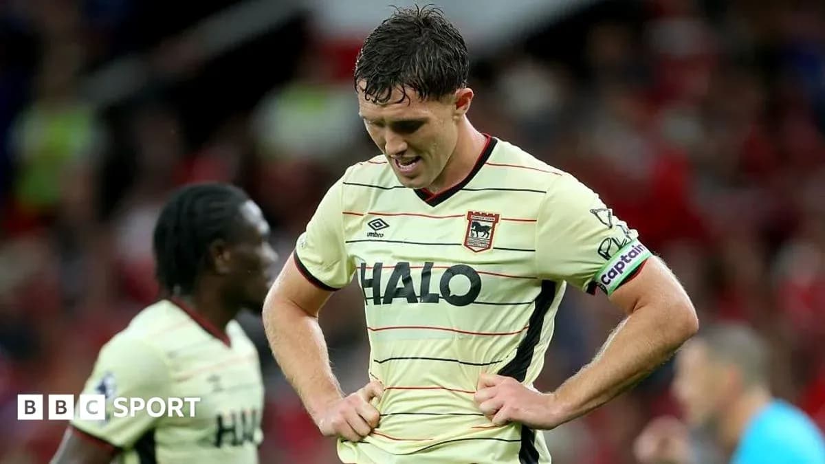 Player with captain's armband looking down in disappointment Player with captain's armband looking down in disappointment