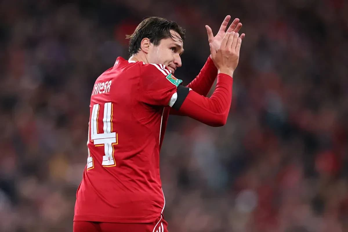Player applauding fans while wearing red kit Player applauding fans while wearing red kit