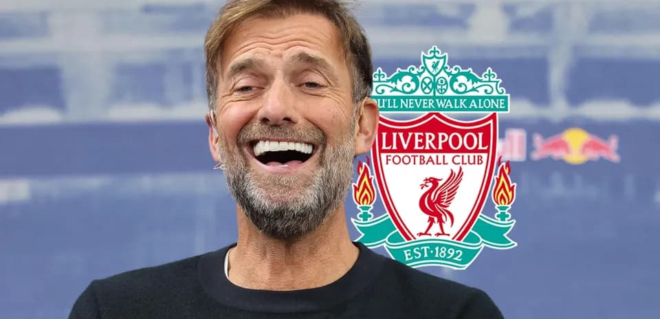 Manager smiling during press conference with Liverpool logo Manager smiling during press conference with Liverpool logo
