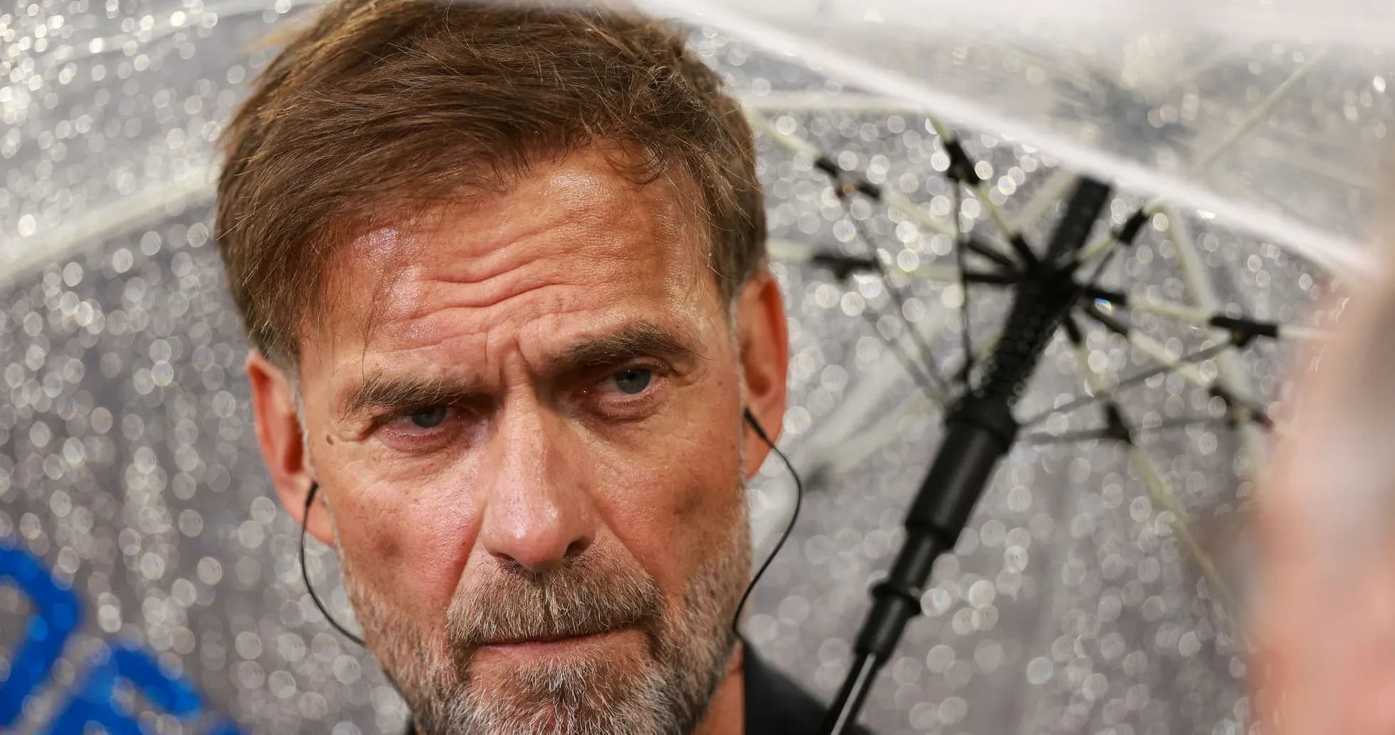Manager under umbrella during rainy press conference Manager under umbrella during rainy press conference