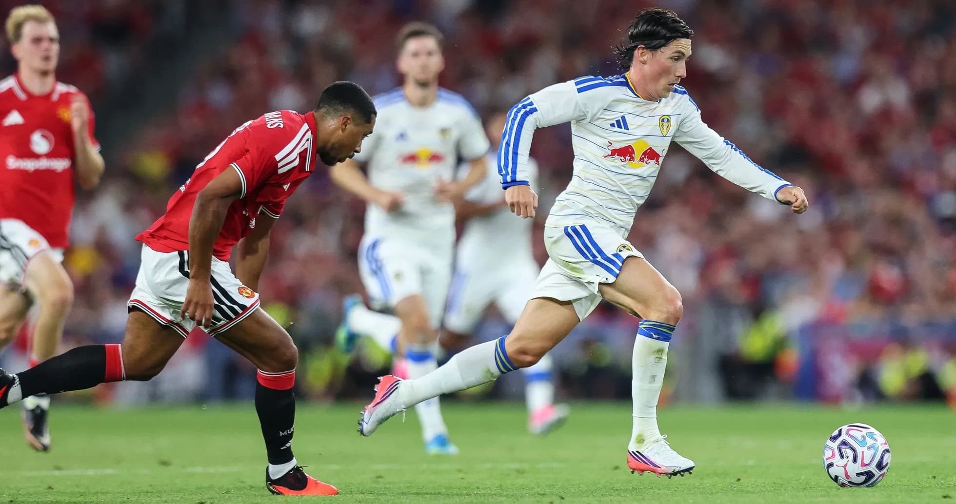 Player in white sprinting past defender in red jersey Player in white sprinting past defender in red jersey