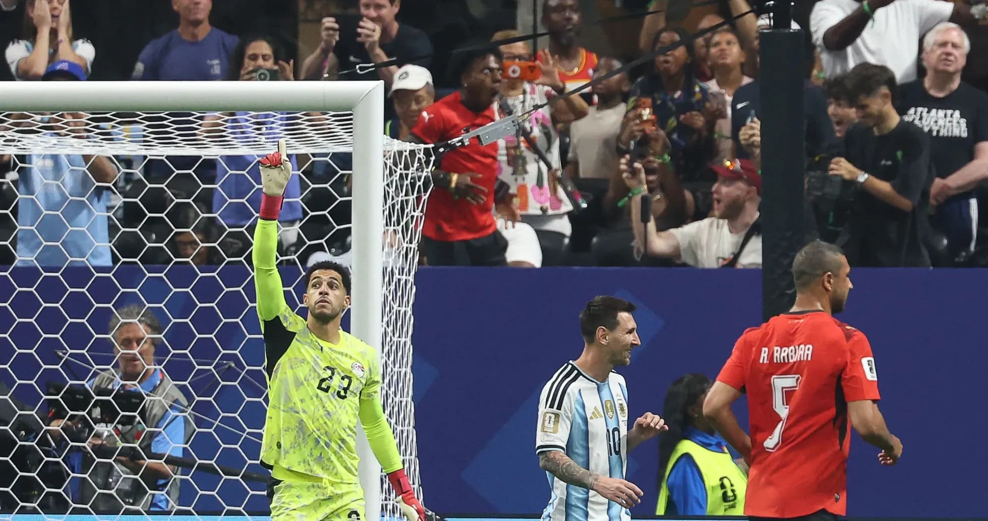 Goalkeeper celebrating a save with players nearby Goalkeeper celebrating a save with players nearby
