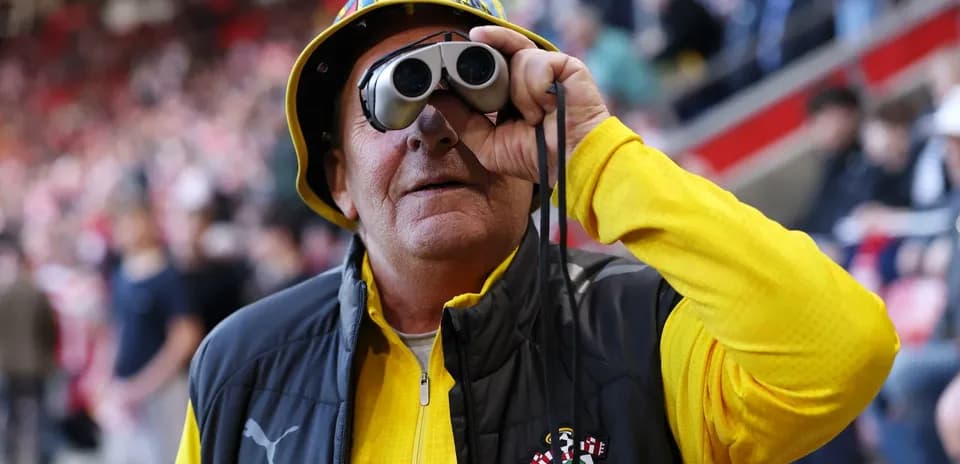 Fan wearing binoculars at a football match Fan wearing binoculars at a football match